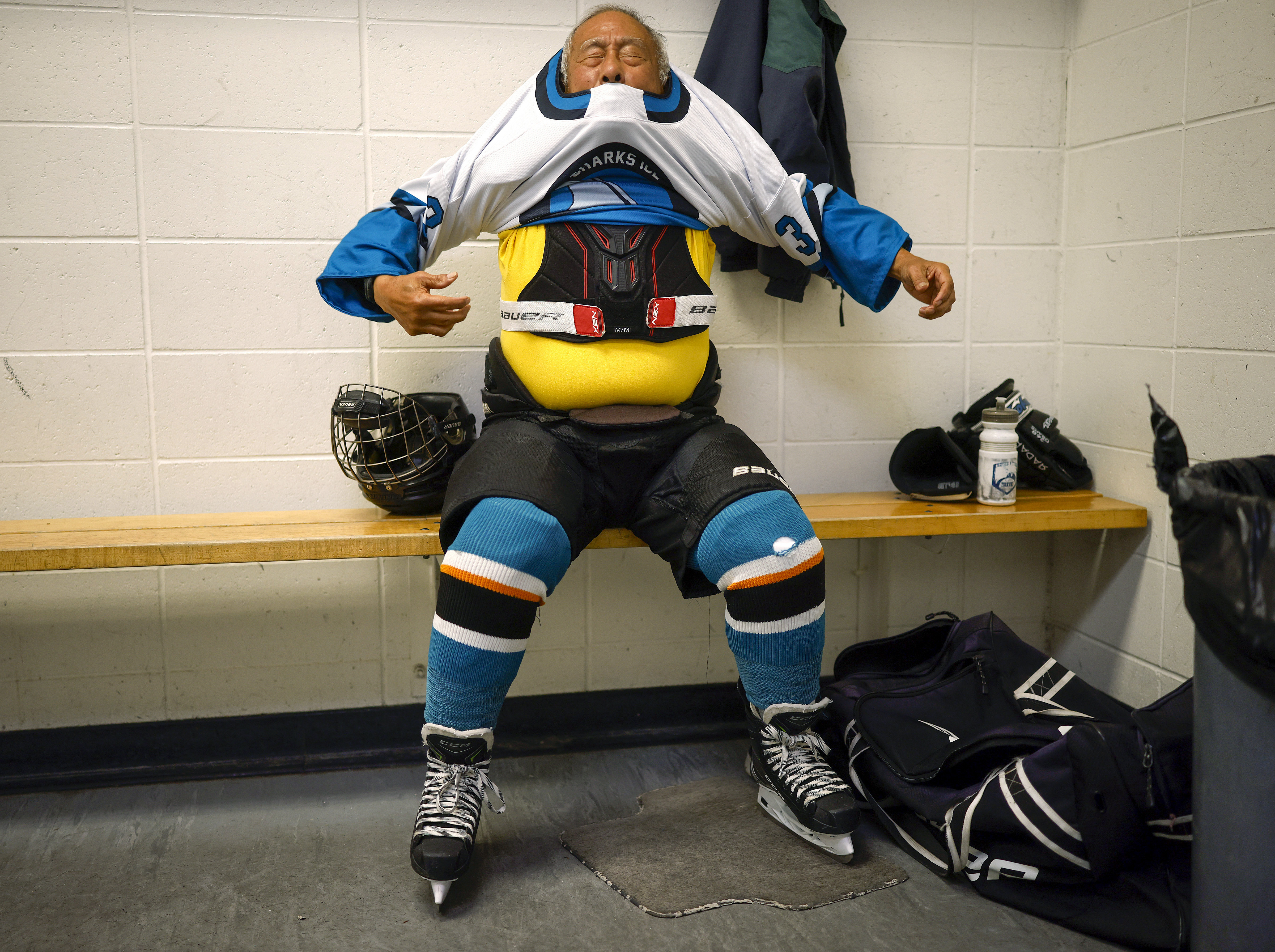 Ed Asato (3), 87, from Sunnyvale, puts on his jersey...