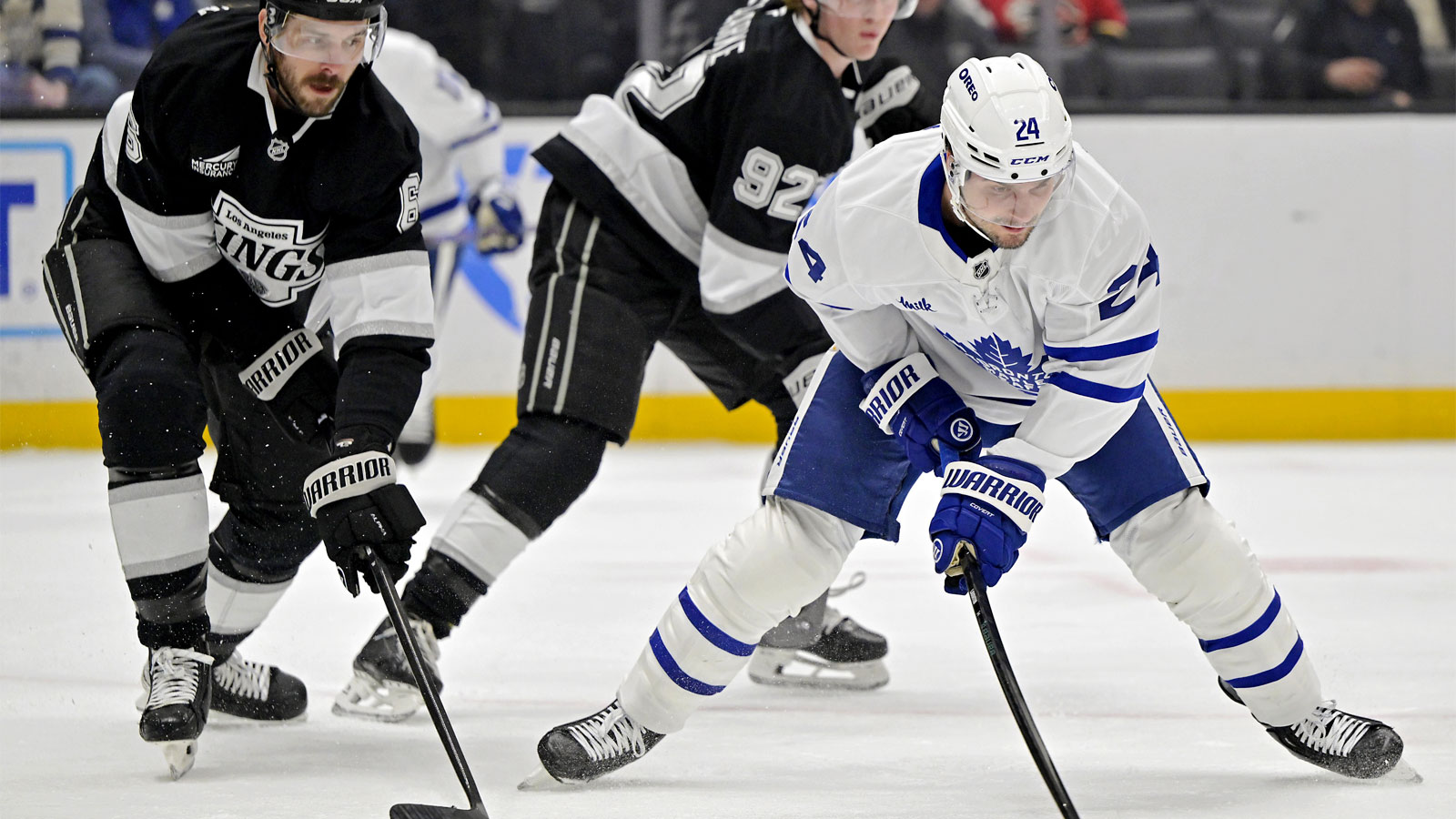 Los Angeles Kings defenseman Joel Edmundson (6) and Toronto Maple Leafs left wing Scott Laughton (24) vie for the puck in the first period at Crypto.com Arena.