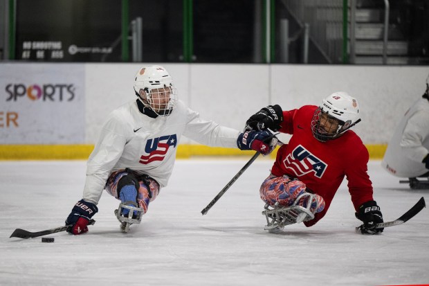 Forward Declan Farmer (16) pushes off forward Malik Jones (19) while handling the puck during a Team USA Sled Hockey practice on Thursday, Feb. 5, 2026, at a Blue Sport Stable ice rink in Superior. (Photo by Timothy Hurst/The Denver Post)