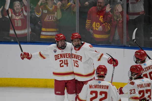 Kieran Cebrian (24), Eric Jamieson (15) and University of Denver teammates celebrate Cebrian's goal against Cornell during the first period of the NCAA West Regional at Blue Arena in Loveland on Friday, March 27, 2026. (Photo by Hyoung Chang/The Denver Post)