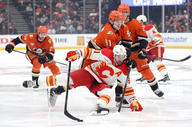 Leo Carlsson #91 and Jacob Trouba #65 of the Anaheim Ducks push Nazem Kadri #91 of the Calgary Flames to the ice during the third period of a game at Honda Center on March 01, 2026 in Anaheim, California. (Photo by Sean M. Haffey/Getty Images)