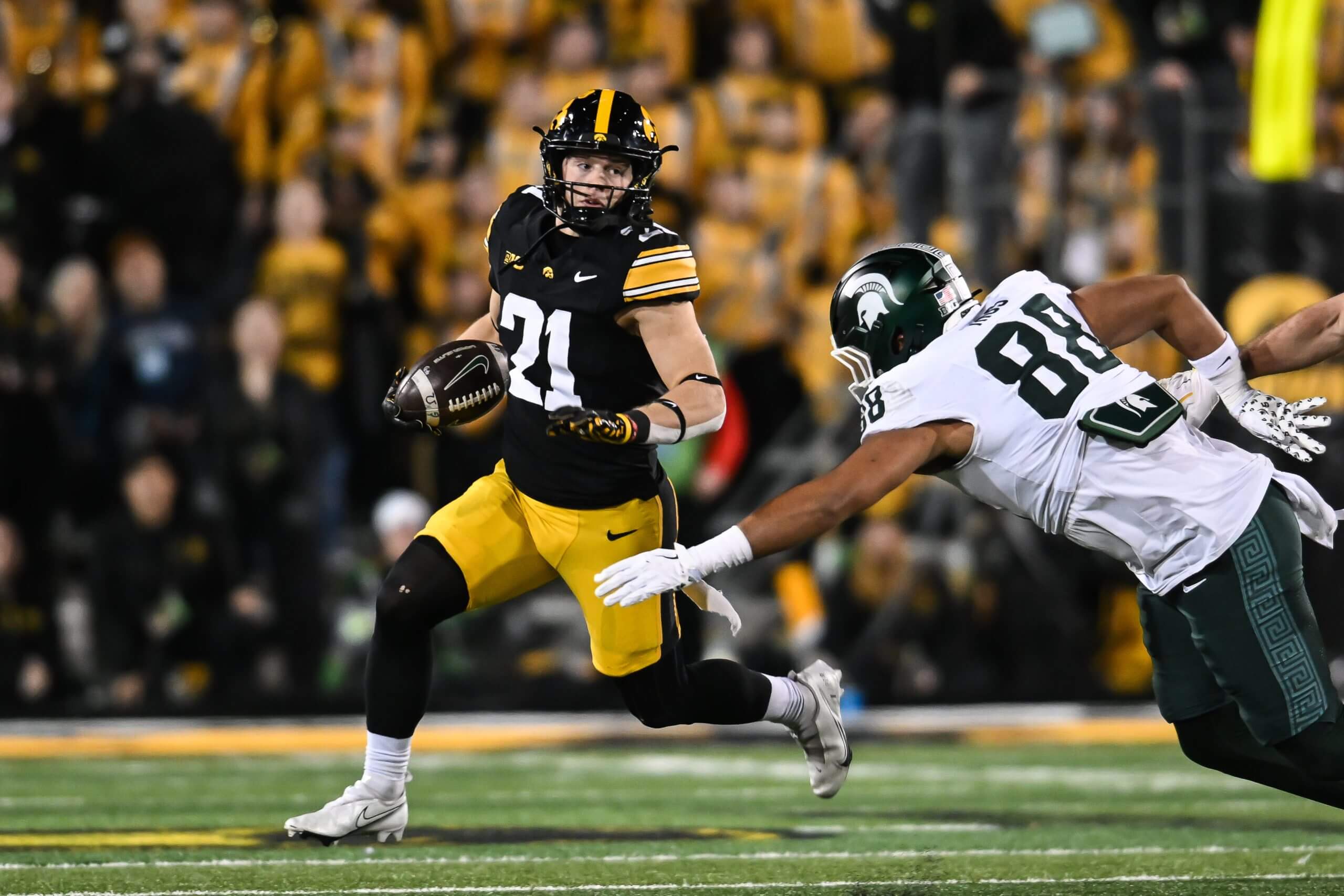 Iowa Hawkeyes wide receiver Kaden Wetjen (21) returns a punt as Michigan State Spartans tight end Kai Rios (88) attempts to make the tackle during the fourth quarter at Kinnick Stadium. 