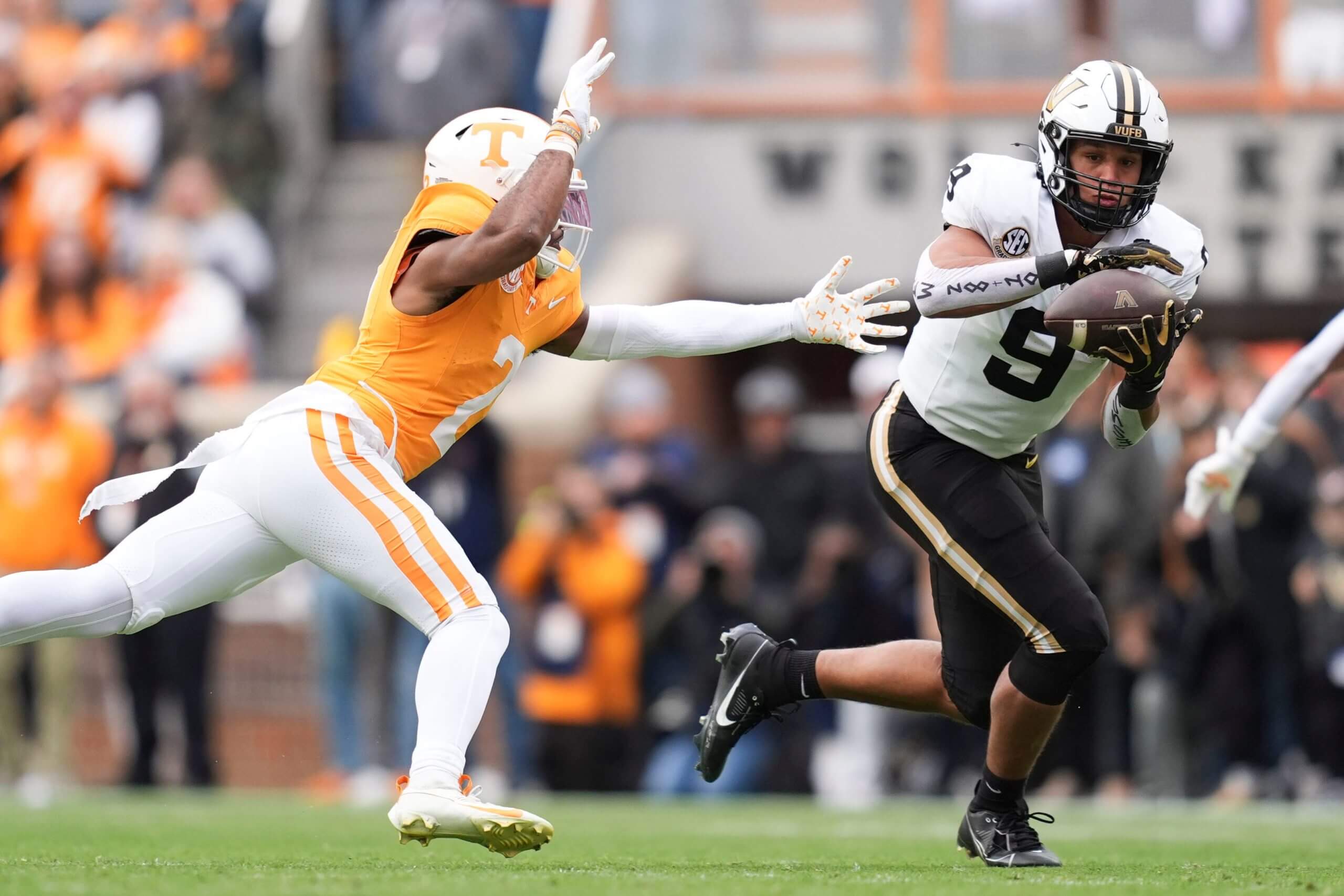 Eli Stowers of Vanderbilt catches a ball against a Tennessee defender.