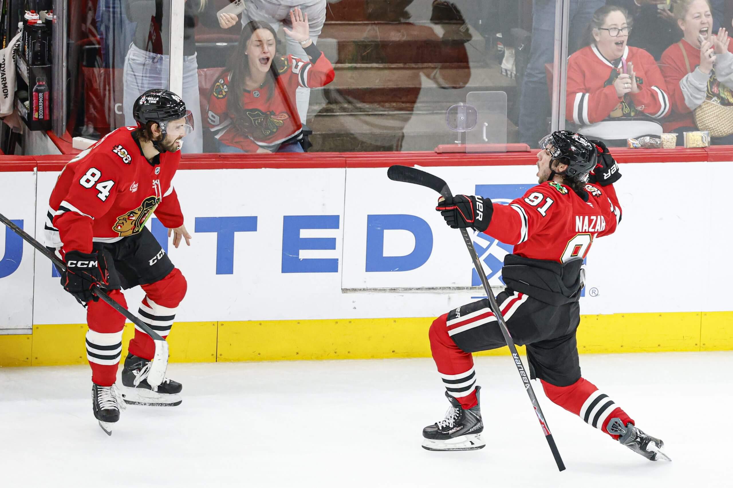Chicago Blackhawks center Frank Nazar, right, wearing No. 91 on his jersey, lunges with his stick in celebration of his game-winning goal with teammate Landon Slaggert.