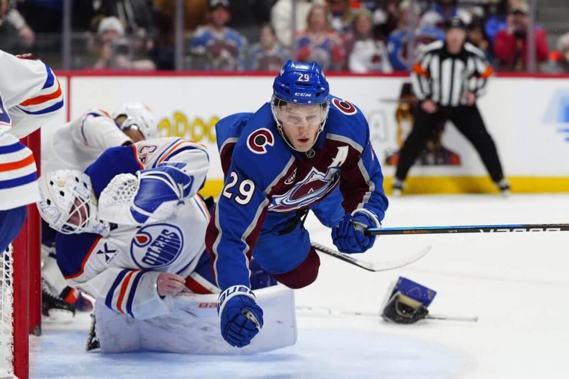 Colorado Avalanche center Nathan MacKinnon collides with Edmonton Oilers goaltender Connor Ingram.