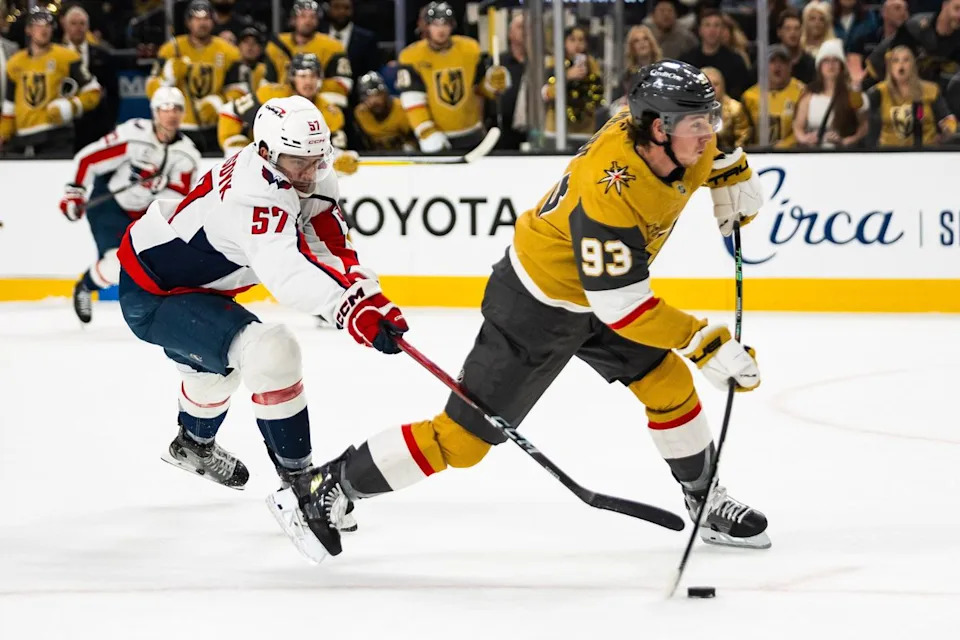 Vegas Golden Knights right-wing Mitch Marner (93) shoots the puck as Washington Capitals defenseman Trevor van Riemsdyk (57) attempts to poke the puck during a NHL game between the Vegas Golden Knights and the Washington Capitals, Saturday March 28, 2026 in Las Vegas, Nev.