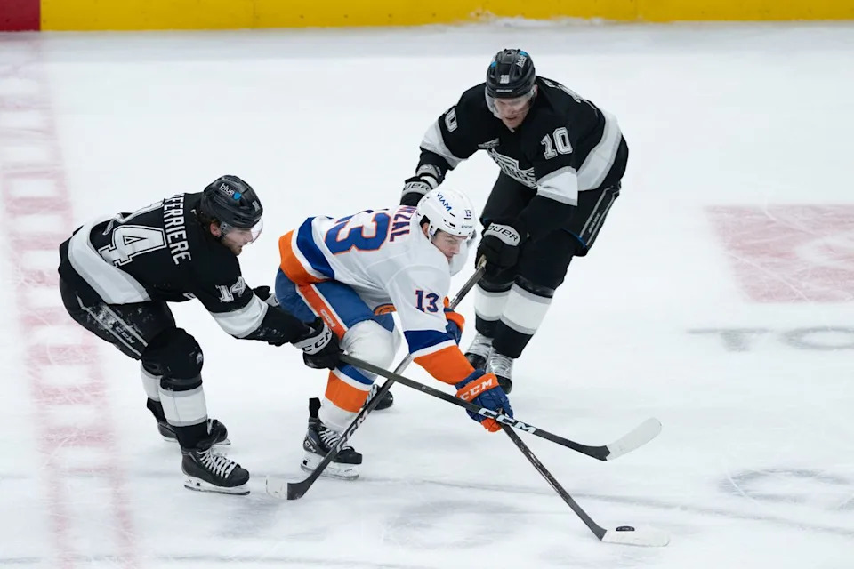 New York Islanders center Mathew Barzal (13) pushes the puck through two defenders during an NHL game between the New York Islanders and the Los Angeles Kings on Thursday, March 5, 2026 at Crypto.com Arena in Los Angeles Calif