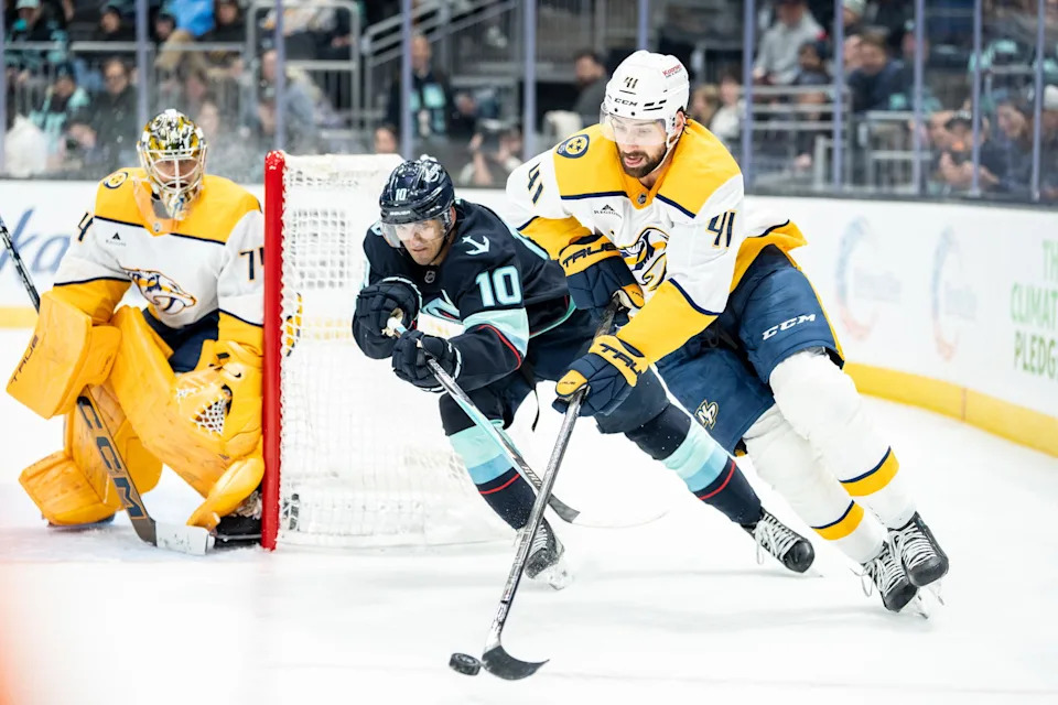 Mar 10, 2026; Seattle, Washington, USA; Nashville Predators defenseman Nicolas Hague (41) and Seattle Kraken forward Matty Beniers (10) battle for the puck during the second period at Climate Pledge Arena. Mandatory Credit: Stephen Brashear-Imagn Images