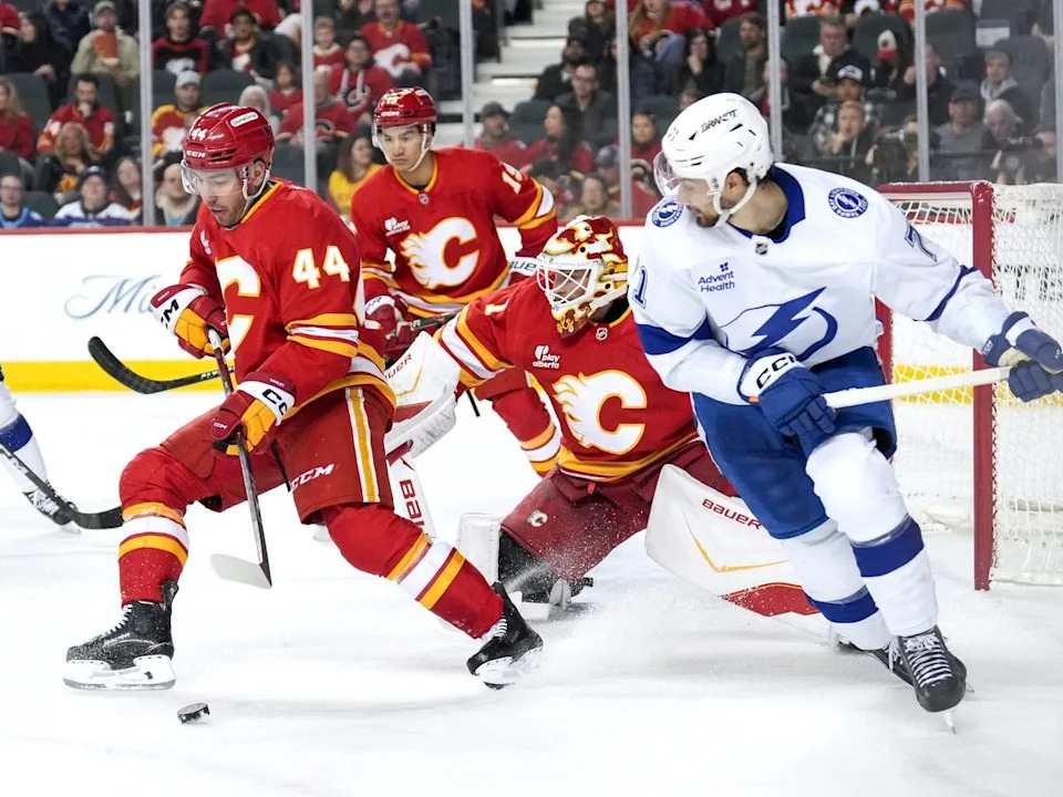  Flames defenceman Joel Hanley looks to clear the puck away from Lightning forward Anthony Cirelli during Sunday’s game.
