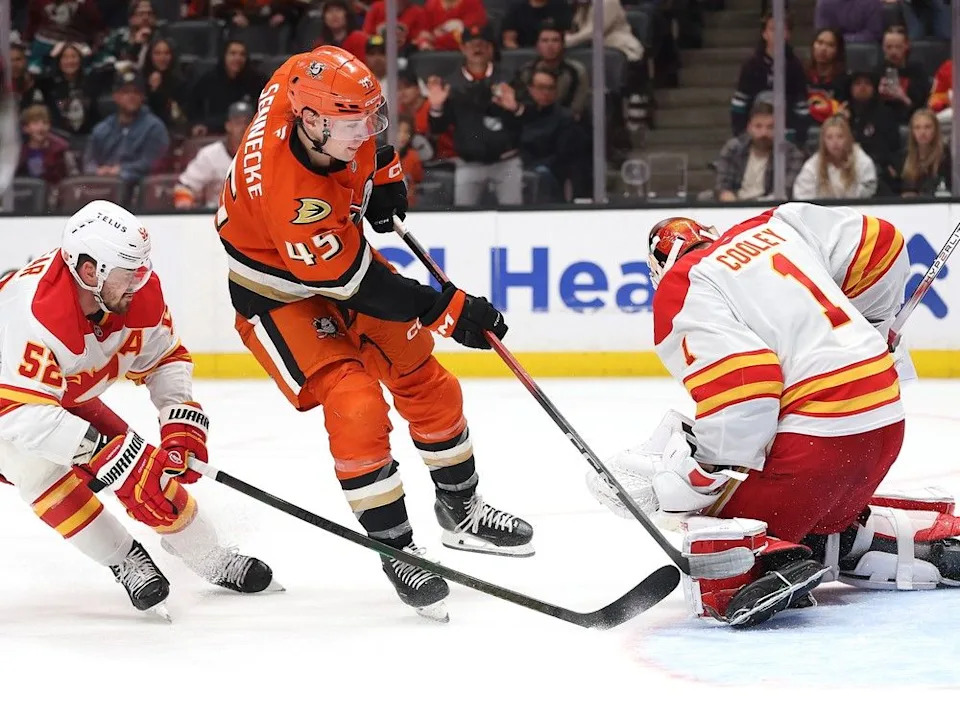  MacKenzie Weegar and Flames goalie Devin Cooley defend against the Ducks’ Beckett Sennecke on Sunday.