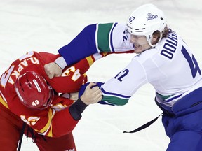 Vancouver Canucks' Curtis Douglas fights Calgary Flames' Adam Klapka during a hockey game in Calgary on Saturday, March 28, 2026.