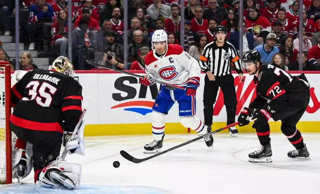 Montreal Canadiens' Nick Suzuki (14) looks for a rebound off of Ottawa Senators' goaltender Linus Ullmark (35) during the first period of an NHL hockey game in Ottawa, Wednesday, March 11, 2026. (Spencer Colby/The Canadian Press via AP)