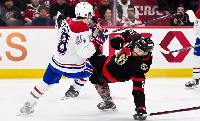 Montreal Canadiens' Lane Hutson (48) collides with Ottawa Senators' Michael Amadio (22) during the second period of an NHL hockey game in Ottawa, on Wednesday, March 11, 2026. (Spencer Colby/The Canadian Press via AP)