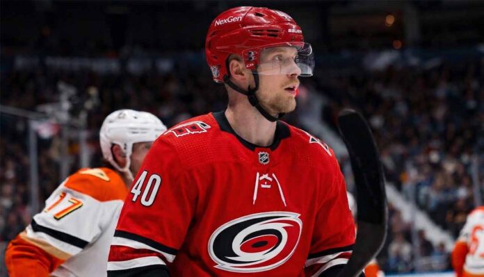 Elias Pettersson of the Vancouver Canucks, wearing the blue orca jersey, looks focused on the ice during an NHL game, fueling trade rumors linking him to the Carolina Hurricanes.