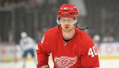 A concept illustration showing current Vancouver Canucks center Elias Pettersson on the ice, wearing a red Detroit Red Wings #40 home jersey and helmet, visualizing recent NHL trade rumors linking the superstar to Detroit.