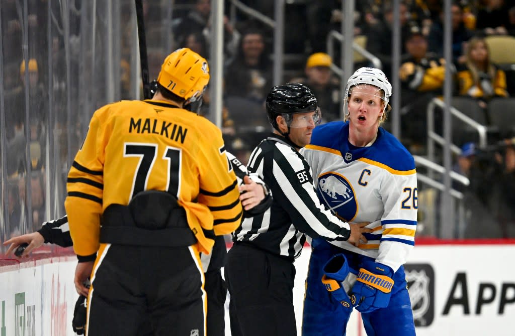 Rasmus Dahlin of the Buffalo Sabres has a disagreement with Evgeni Malkin of the Penguins on March 5. NHLI via Getty Images