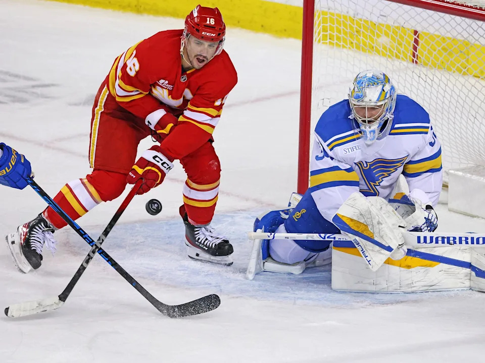  Calgary Flames forward Morgan Frost eyes a flying puck with St. Louis Blues goaltender Joel Hofer during NHL action at the Scotiabank Saddledome in Calgary on Wednesday, March 18, 2026.Gavin Young/Postmedia