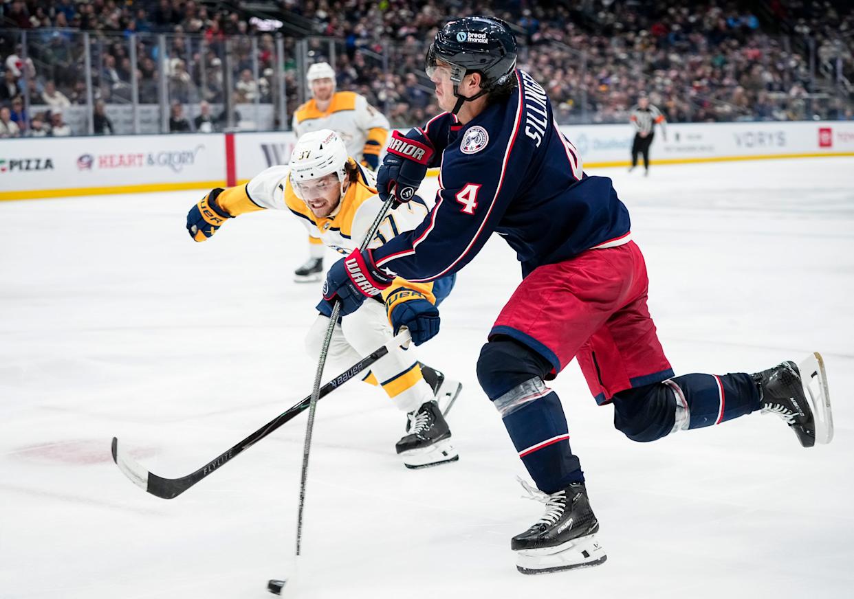 Blue Jackets center Cole Sillinger shoots past Nashville Predators defenseman Nick Blankenburg on March 3.