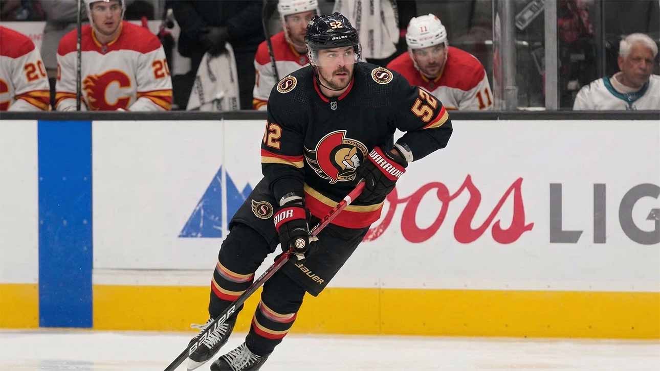 Ottawa Senators #52 MacKenzie Weegar skating with the puck on ice.