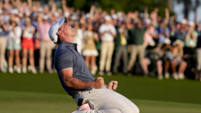 Apr 13, 2025; Augusta, Georgia, USA; Rory McIlroy falls to his knees in celebration after winning a playoff on the no. 18 green during the final round of the Masters Tournament at Augusta National Golf Club.