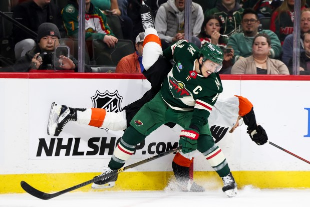 Minnesota Wild defenseman Jared Spurgeon, front, upends Philadelphia Flyers right wing Nikita Grebenkin, behind, during the second period of an NHL hockey game, Thursday, March 12, 2026, in St. Paul, Minn. (AP Photo/Ellen Schmidt)