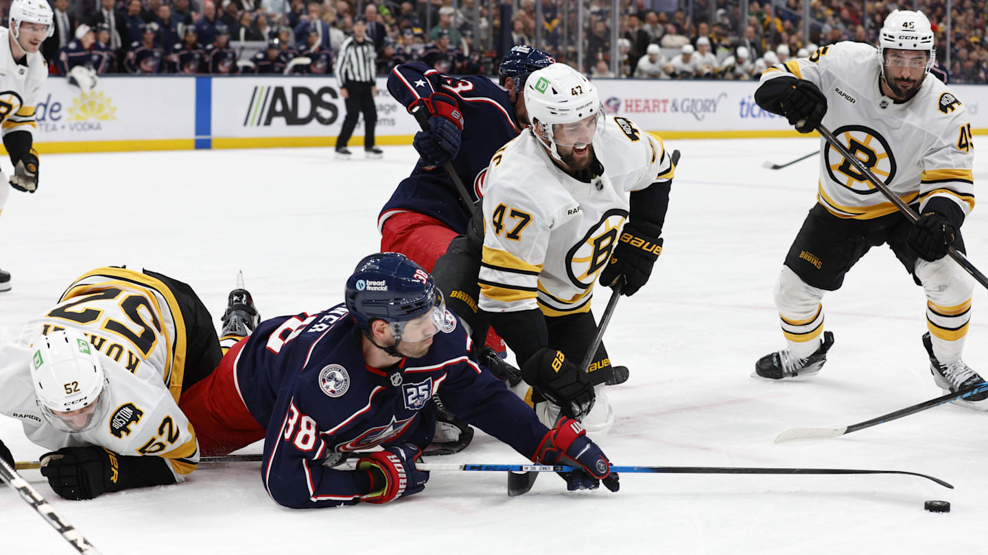 Mar 29, 2026; Columbus, Ohio, USA; Columbus Blue Jackets center Boone Jenner (38) reaches for the loose puck with Boston Bruins center Mark Kastelic (47) during the second period at Nationwide Arena. Mandatory Credit: Russell LaBounty-Imagn Images