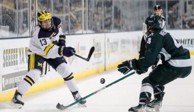 Michigan center TJ Hughes makes a pass against Michigan State defenseman Nash Nienhuis during the third period at Yost Ice Arena in Ann Arbor on Friday, Feb. 9, 2024.