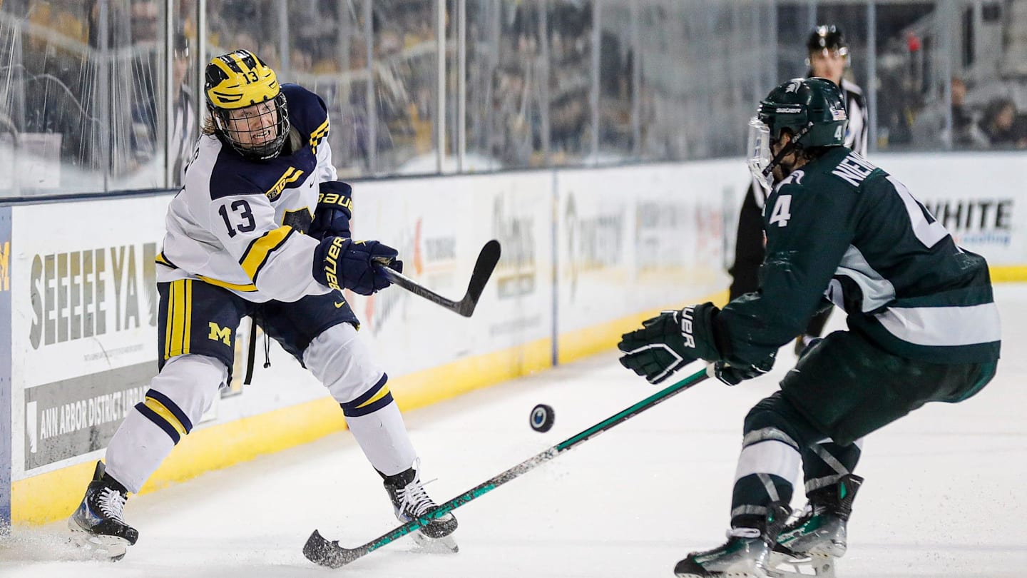 Michigan center TJ Hughes makes a pass against Michigan State defenseman Nash Nienhuis during the third period at Yost Ice Arena in Ann Arbor on Friday, Feb. 9, 2024.