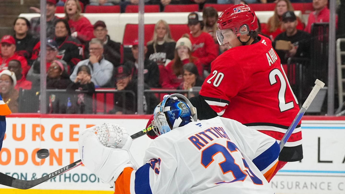 Oct 30, 2025; Raleigh, North Carolina, USA;  New York Islanders goaltender David Rittich (33) makes save in front of Carolina Hurricanes center Sebastian Aho (20) during the third period at Lenovo Center. Mandatory Credit: James Guillory-Imagn Images