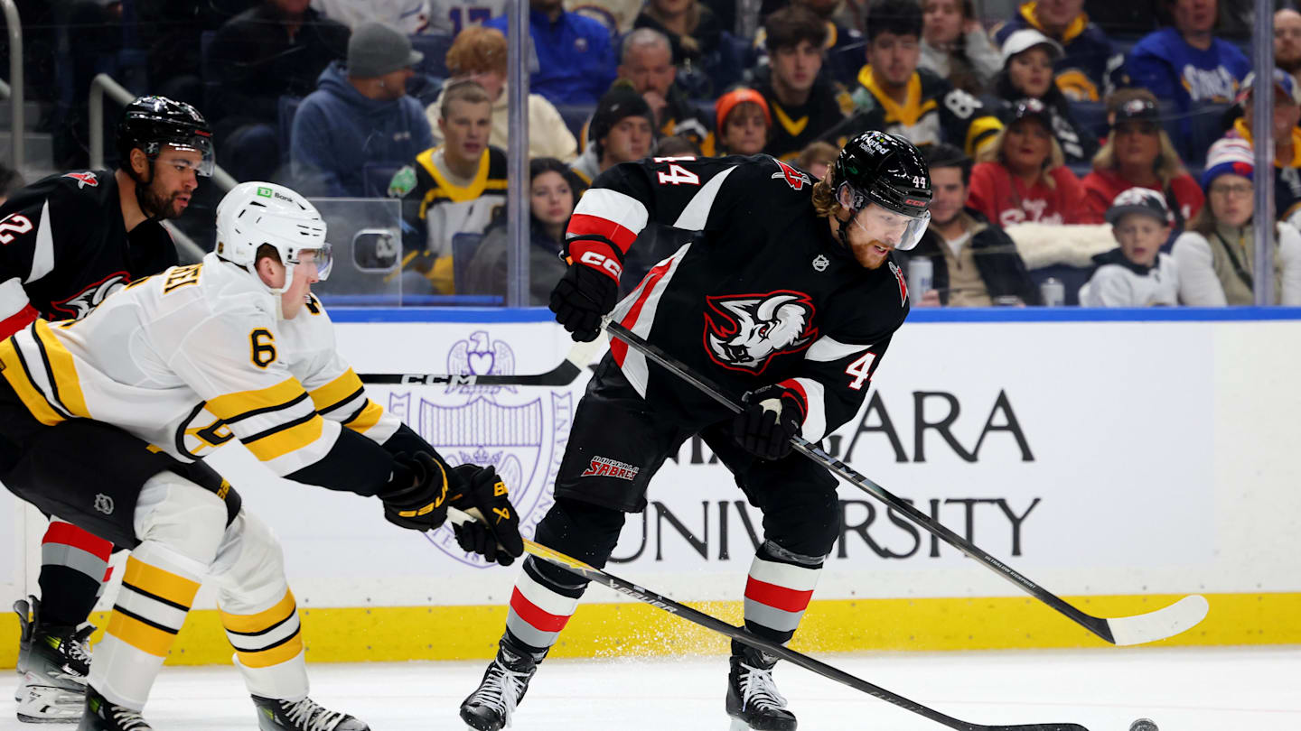 Dec 27, 2025; Buffalo, New York, USA;  Boston Bruins defenseman Mason Lohrei (6) defends as Buffalo Sabres center Josh Dunne (44) tries to control the puck during the second period at KeyBank Center. Mandatory Credit: Timothy T. Ludwig-Imagn Images