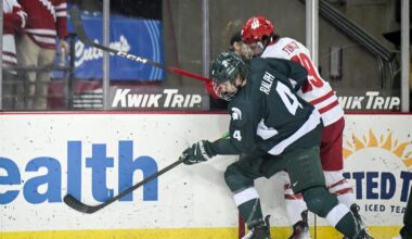 Michigan State defenseman Colin Ralph (4) and Wisconsin left wing Quinn Finley (19) collide along the boards in a game Thursday, January 15, 2026, at the Kohl Center in Madison, Wisconsin.