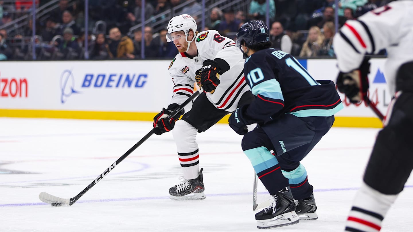 Nov 3, 2025; Seattle, Washington, USA; Chicago Blackhawks defenseman Sam Rinzel (6) passes the puck past Seattle Kraken center Matty Beniers (10) in the first period at Climate Pledge Arena. Mandatory Credit: Kevin Ng-Imagn Images