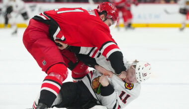 Jan 22, 2026; Raleigh, North Carolina, USA;  Carolina Hurricanes defenseman Alexander Nikishin (21) and Chicago Blackhawks center Oliver Moore (11) fight during the second period at Lenovo Center. Mandatory Credit: James Guillory-Imagn Images
