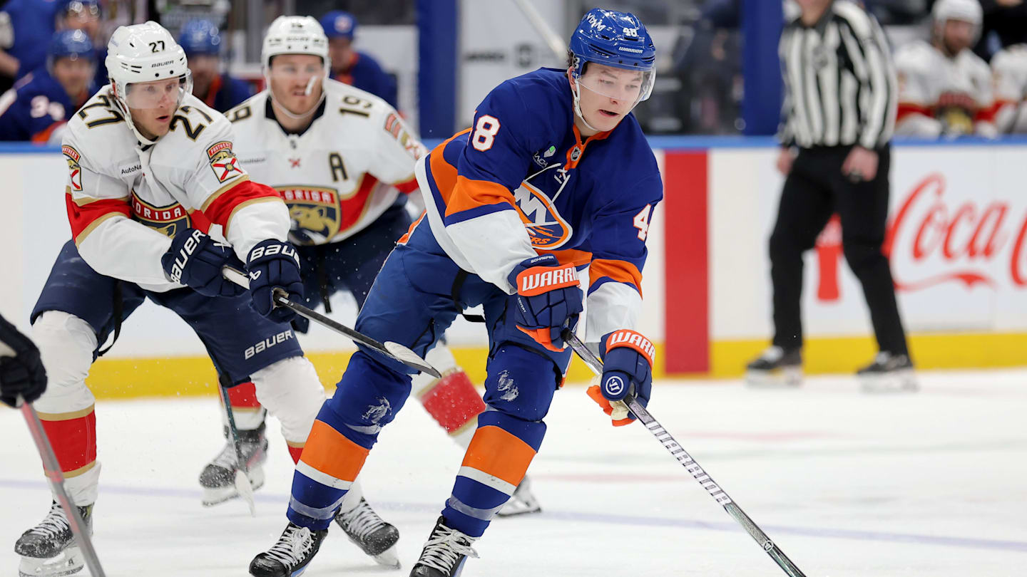 Mar 28, 2026; Elmont, New York, USA; New York Islanders defenseman Matthew Schaefer (48) plays the puck against Florida Panthers center Eetu Luostarinen (27) and left wing Matthew Tkachuk (19) during the second period at UBS Arena. Mandatory Credit: Brad Penner-Imagn Images