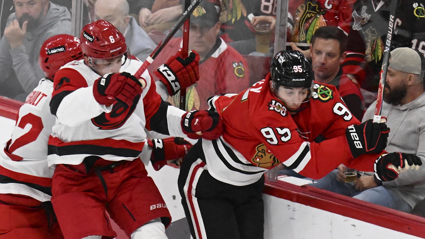 Apr 9, 2026; Chicago, Illinois, USA;  Carolina Hurricanes defenseman Mike Reilly (6) checks Chicago Blackhawks right wing Ilya Mikheyev (95) during the second period at the United Center. Mandatory Credit: Matt Marton-Imagn Images