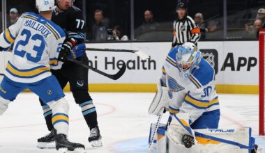 Apr 16, 2026; Salt Lake City, Utah, USA; St. Louis Blues goaltender Joel Hofer (30) blocks a shot while defenseman Logan Mailloux (23) and right wing JJ Peterka (77) play for a rebound during the first period at Delta Center. Mandatory Credit: Rob Gray-Imagn Images