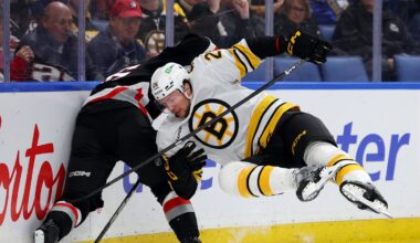 Dec 27, 2025; Buffalo, New York, USA;  Boston Bruins defenseman Andrew Peeke (26) tries to check Buffalo Sabres center Noah Ostlund (86) as he goes after the puck during the second period at KeyBank Center. Mandatory Credit: Timothy T. Ludwig-Imagn Images