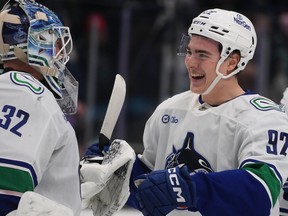 Vancouver Canucks left wing Liam Ohgren, right, greets goaltender Kevin Lankinen, left, as they celebrate after Ohgren's game-winning goal in a shootout against the Seattle Kraken on Dec. 29, 2025, in Seattle.