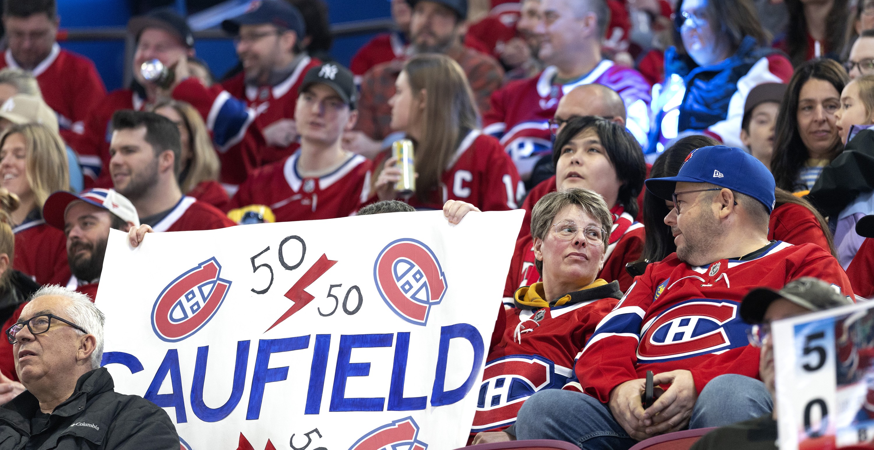 Montreal Canadiens fans hold up a sign cheering on Cole Caufield's attempt to reach 50 goals.