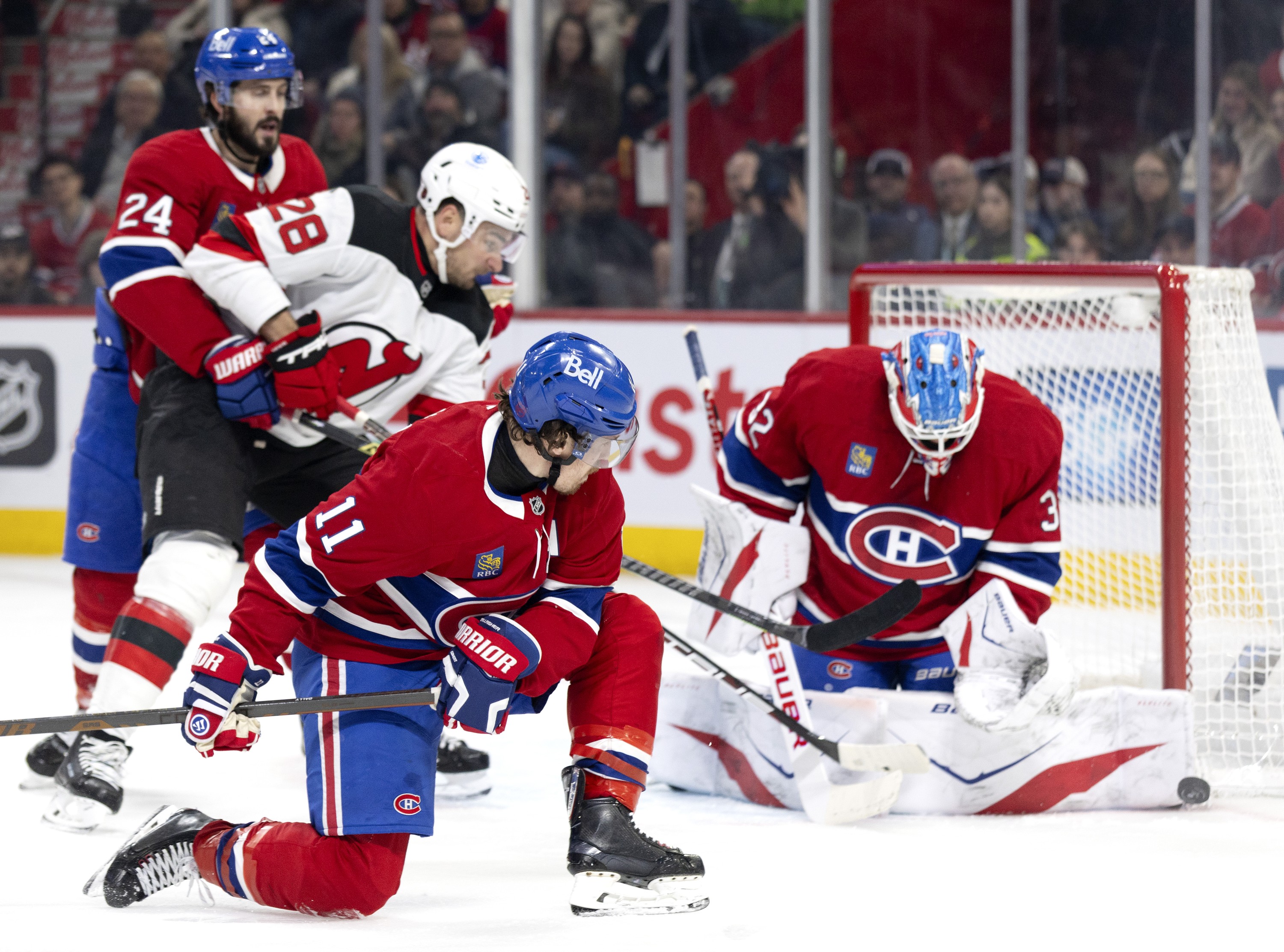 Montreal Canadiens right wing Brendan Gallagher looks back to see Canadiens goaltender Jacob Fowler make a save against the New Jersey Devils.