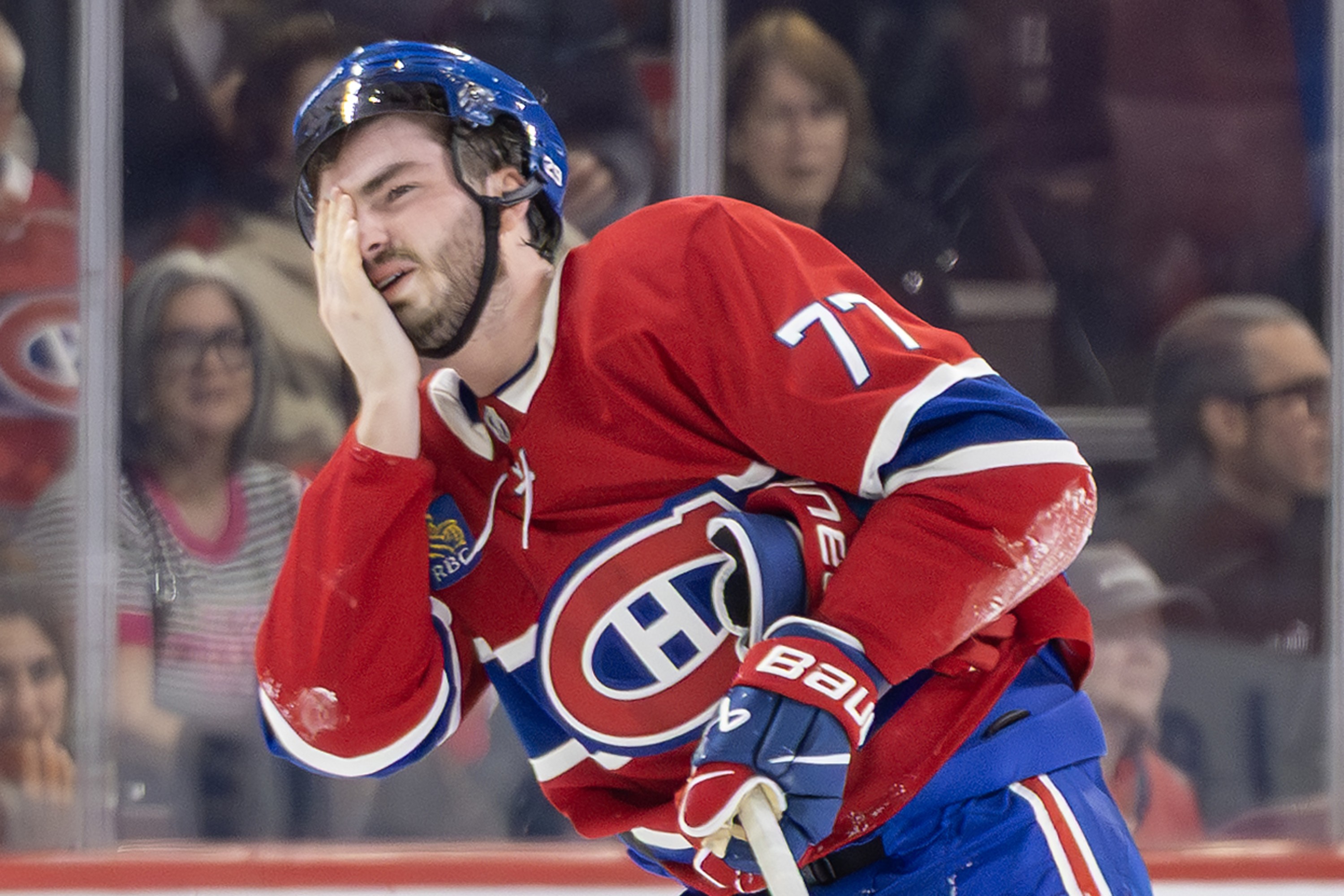 Canadiens' Kirby Dach holds his hand to his right eye.