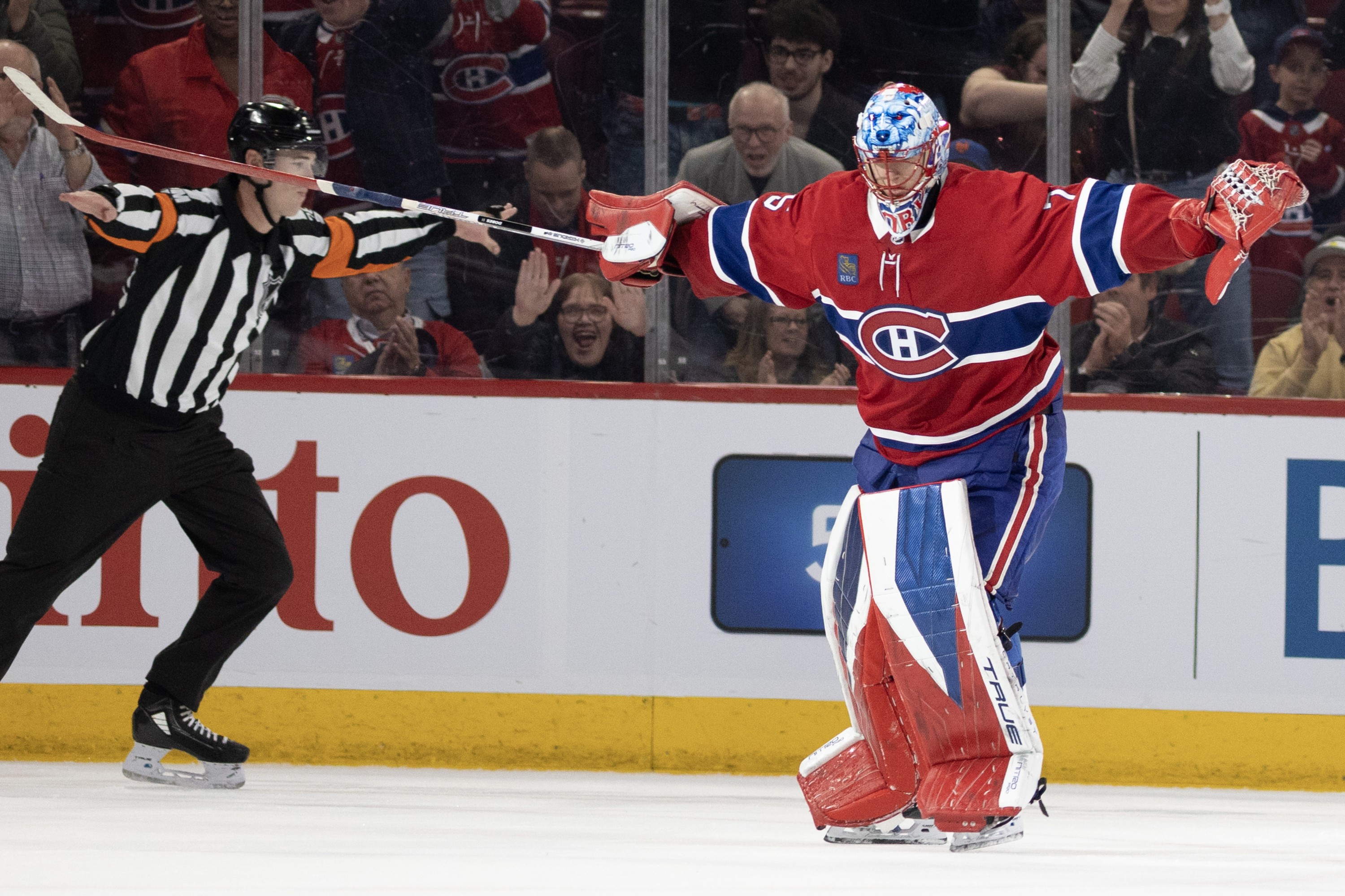 Jakub Dobes stretches his arms out to signal no goal as a referee does the same on the ice.