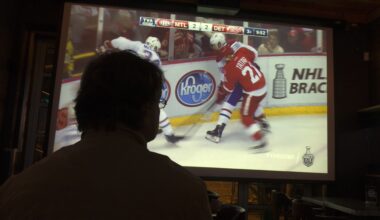 A Montreal Canadiens fans watches a game on TV in a dark room.