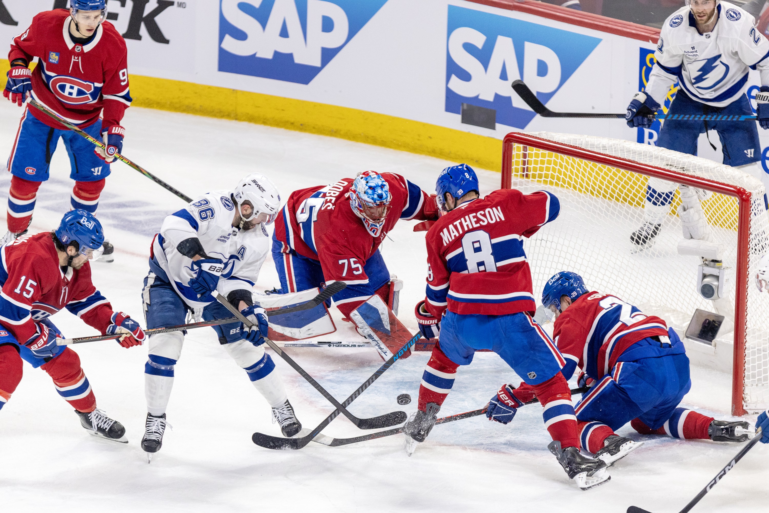 Montreal Canadiens goalie Jakub Dobes scrambles to get back to his net as Alex Newhook, Mike Matheson and Kaiden Guhle try to tie up Tampa Bay Lightning's Nikita Kucherov.