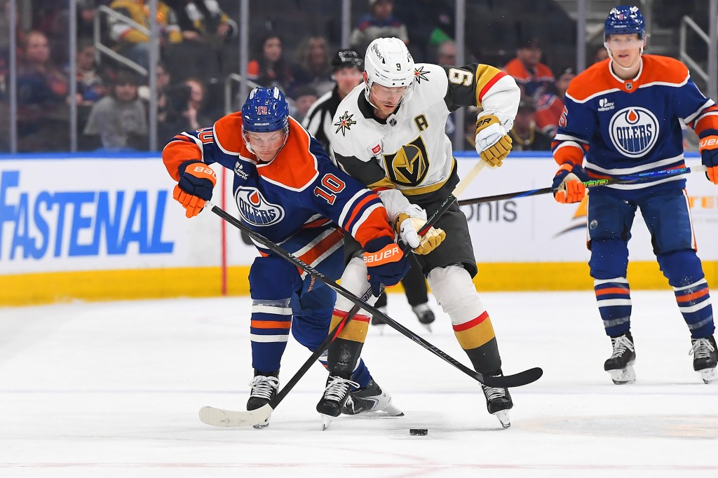 Trent Frederic #10 of the Edmonton Oilers battles for the puck against Jack Eichel #9 of the Vegas Golden Knights during the third period of the game at Rogers Place on April 4, 2026, in Edmonton, Alberta, Canada. 