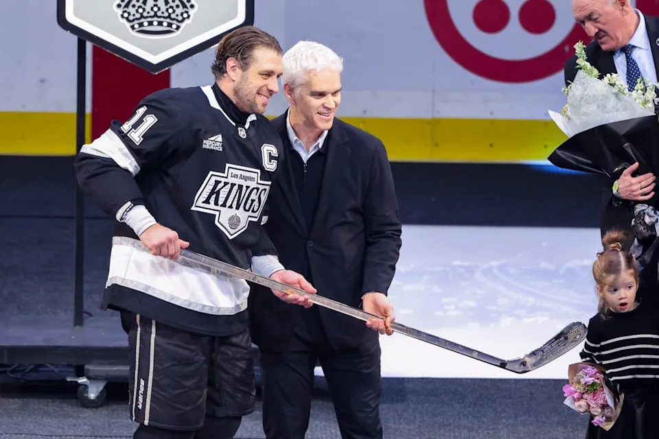 Former Los Angeles Kings player Luc Robitaille gives Anze Kopitar #11 of the Los Angeles Kings a golden stick before an NHL hockey game against the Nashville Predators, Thursday April 2, 2026 in Los Angeles, Calif.
