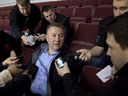 Canucks GM Mike Gillis, centre, takes questions from reporters as he watches a team practice at Rogers Arena on May 27, 2011.
