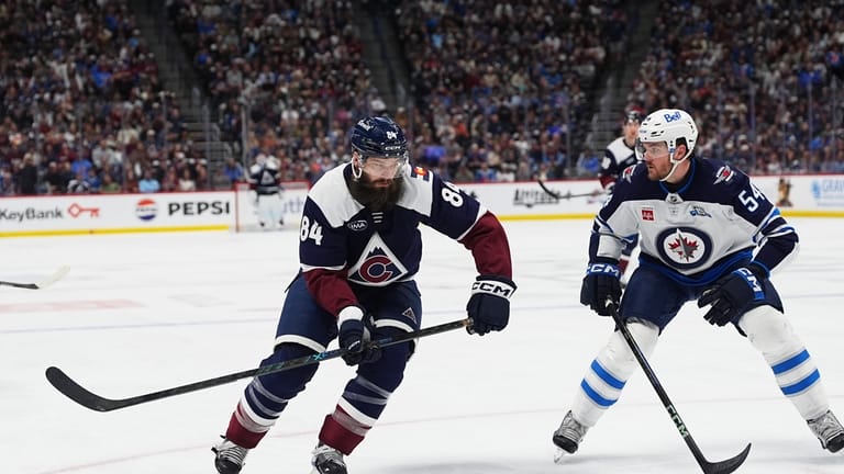 Colorado Avalanche defenseman Brent Burns, left, drives past Winnipeg Jets...