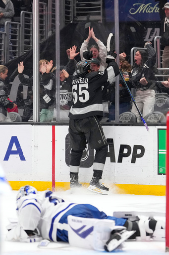 Los Angeles Kings right wing Quinton Byfield, top, celebrates after scoring the game-winning goal as Toronto Maple Leafs goaltender Joseph Woll lays on the ice during overtime of an NHL hockey game Saturday, April 4, 2026, in Los Angeles. (AP Photo/Mark J. Terrill)