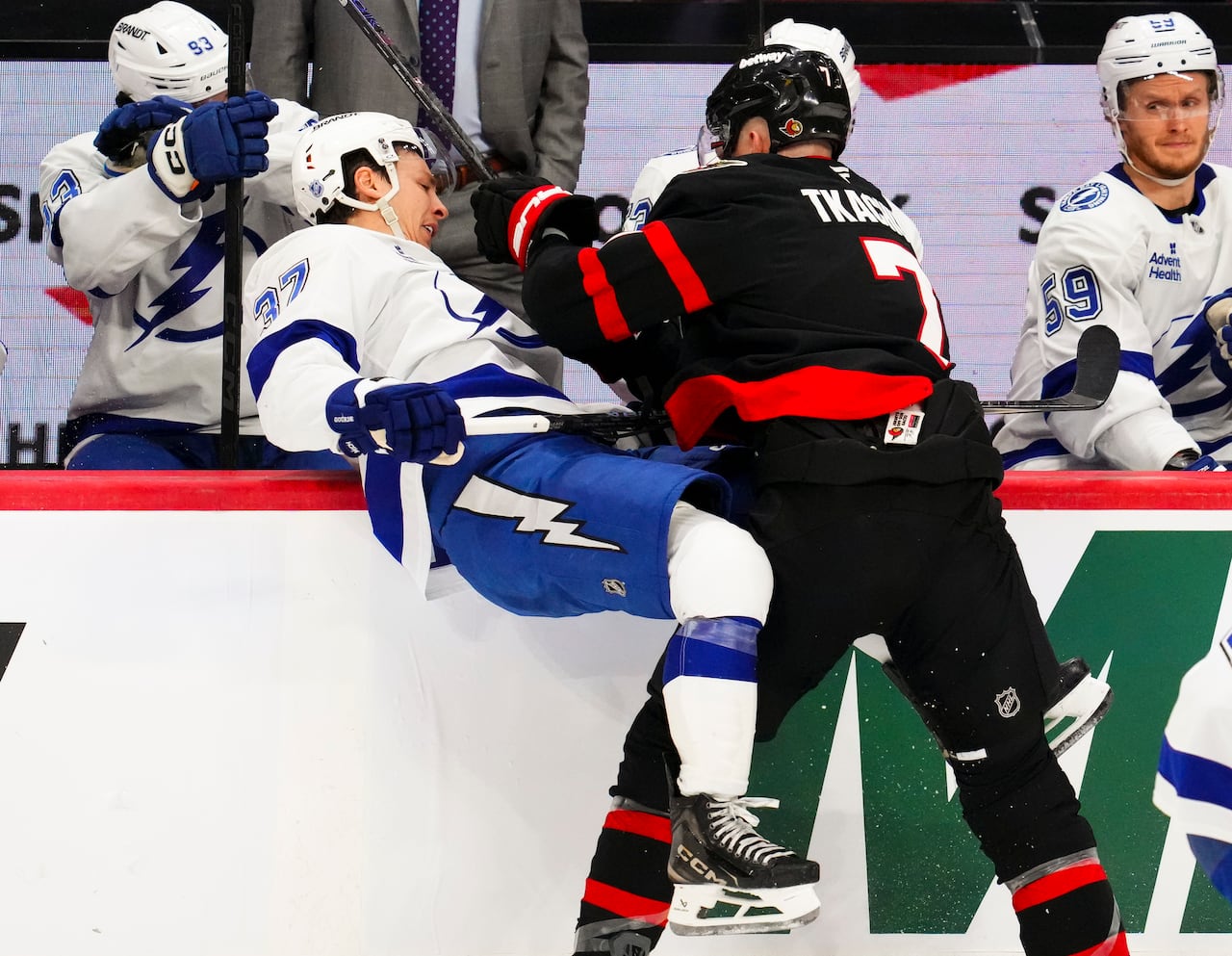 A hockey player knocks an opponent into his own bench with a bodycheck.